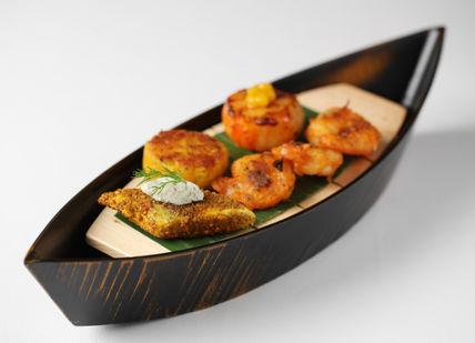 An image of a boat with food in it, Five-Course Tasting Menu. Quilon