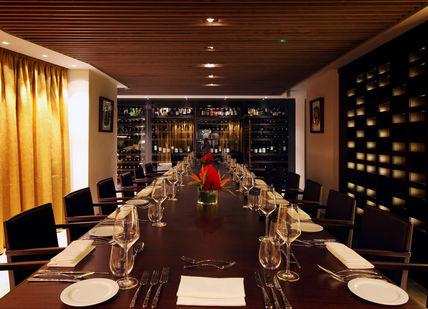 An image of a restaurant setting with a long table, Private Four-Course Dinner. Quilon