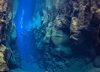An image of a cave with a diver, Private Airport Transfer. Reykjavik Konsulat Hotel Curio Collection By Hilton