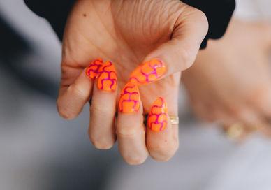 An image of a person holding a pink and orange nail, Nail Art Workshop. ROYAL ARSENAL ACADEMY
