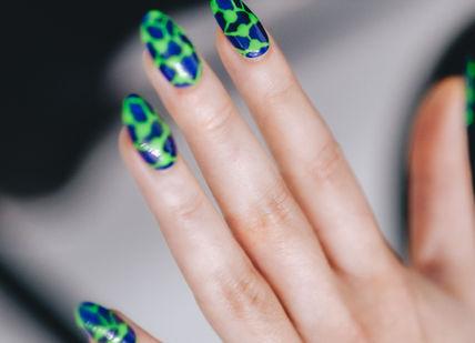 An image of a woman's hand with green and black nail polish, Nail Art Workshop. ROYAL ARSENAL ACADEMY