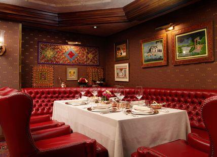 An image of a restaurant setting with red leather chairs, The Rubens at the Palace - The Curry Room. The Rubens at the Palace - The Curry Room