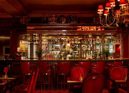 An image of a bar with red chairs, The Rubens at the Palace- The New York Bar. The Rubens at the Palace - The New York Bar