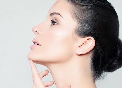 An image of a woman with her hand on her chin, Santi Glow Facial. Santi Spa London
