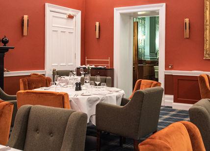 An image of a restaurant setting with a fireplace, Scottish Golf Getaway. SCHLOSS Roxburghe Hotel