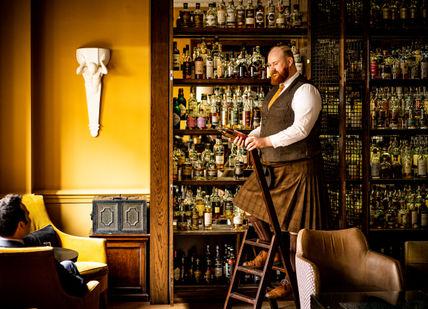 An image of a man in a bar, 100 Years of Whisky Journey. Scotch at The Balmoral
