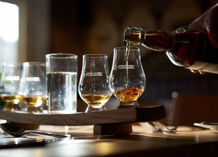 An image of a person pouring whiskey into glasses, The Platinum Tour. Scotch Whisky Experience