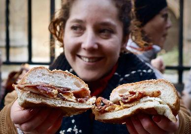 An image of a woman eating a sandwich, London Bridge Secret Food Tour. Secret Food Tours