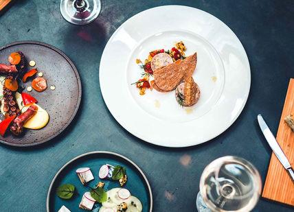 An image of a table with plates of food, Exclusive Tasting Menu with Wine Pairing. Shears Yard