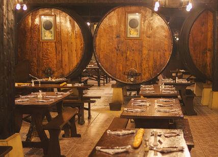 An image of a restaurant setting with wine barrels, Dinner (Menu 5). Sideria Petritegi