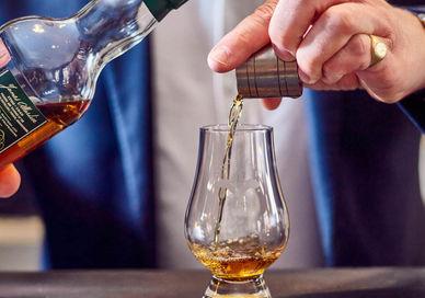 An image of a person pouring a drink, Scotch vs The World Whisky Experience. Soho Whisky Club
