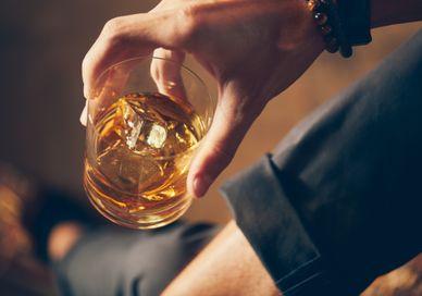 An image of a person holding a glass of whiskey, Whisky Tasting. Soho Whisky Club