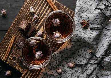 An image of a tray with two glasses of tea, William Curley Chocolates and Whisky Pairing. Soho Whisky Club