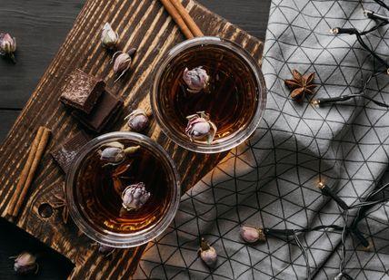 An image of a tray with two glasses of tea, William Curley Chocolates and Whisky Pairing. Soho Whisky Club