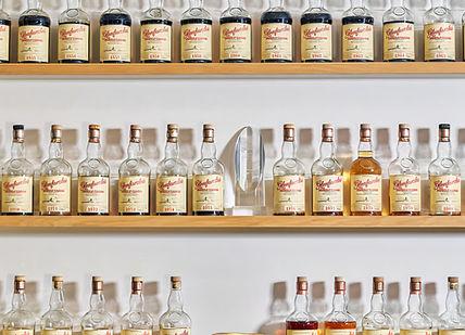 An image of bottles of alcohol on a shelf, Soho Whisky Club. Soho Whisky Club