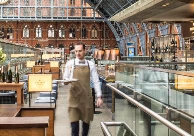 An image of a large building with glass walls, St Pancras Brasserie & Champagne Bar by Searcys. St Pancras Brasserie & Champagne Bar by Searcys