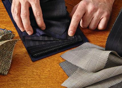 An image of a person putting a cloth, Create a Bespoke Two-Piece Suit. Stowers London