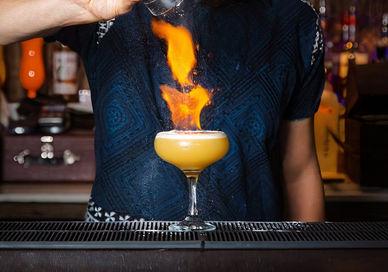 An image of a woman making a drink, Old Time Classic Cocktails With A Meal. Sugar Cane Bar