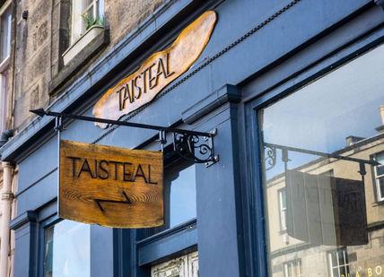 An image of a restaurant sign hanging on the side of a building, Edinburgh, Scotland. Taisteal