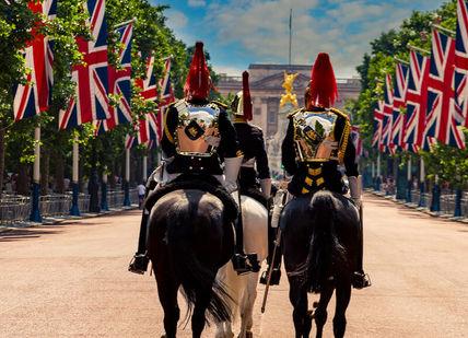 An image of two men riding horses with flags, London Bike Tour. Tally Ho