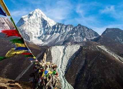 An image of a mountain with flags flying in the air, 7-Day Everest Base Camp Trekking And Helicopter Trip. Trekking Guide Team Adventure