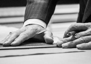 An image of a person's hands on a piece of paper, Turnbull & Asser - London. Turnbull & Asser - London