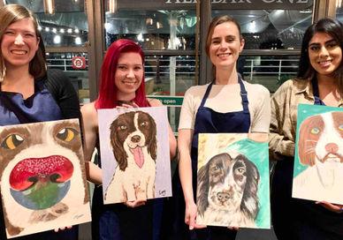 An image of three women holding paintings of dogs, Paint Your Pet Workshop. Undergrounder