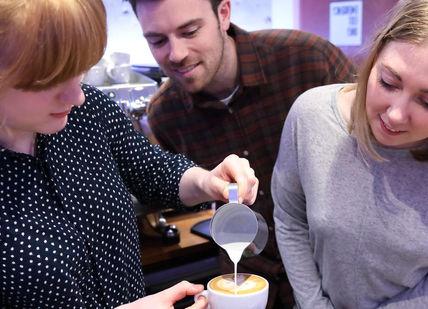 An image of a woman pouring coffee into a cup, Latte Art Masterclass. Union Brew Lab