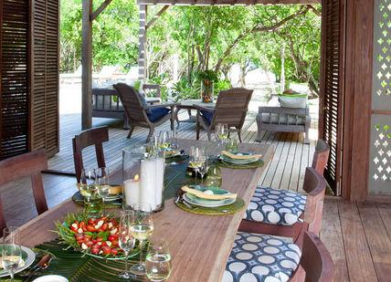 An image of a dining area with wooden shutters, Kitala suite on Vamizi Island. Vamizi Island