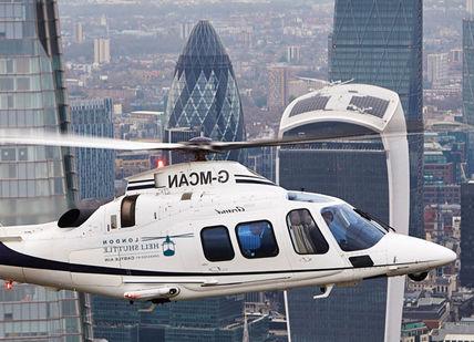 An image of a helicopter flying over a city, Helicopter transfer. Veloce Driving Ltd