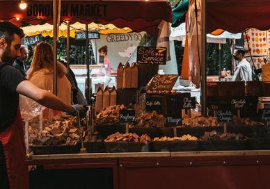 An image of a man selling food at a market, In front of Caffe Nomma Italian. Walk Eat Talk Eat