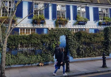 An image of a blue house with blue shutters, Notting Hill, London. Walk Eat Talk Eat