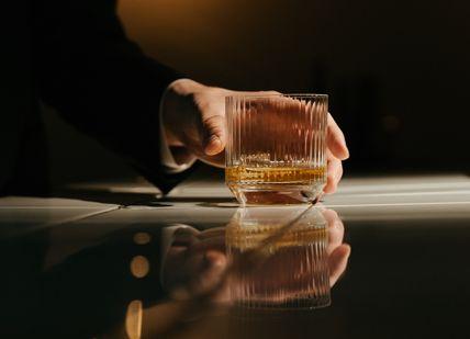 An image of a person holding a glass, Premium Whiskey Tasting. Whiski Rooms