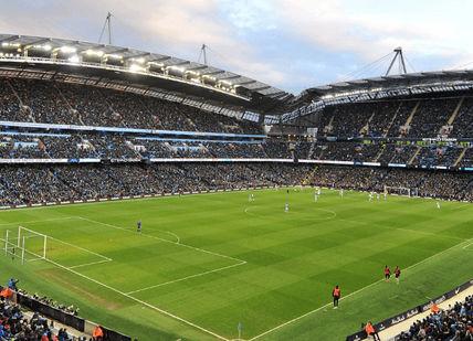 An image of a soccer stadium with a large crowd, The Anthem Manchester City Football Experience. Wonderment Entertainment