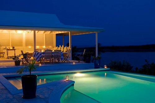 The infinity pool at Little Whale Cay lit up at night