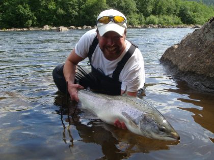 Man catching big fish after fly fishing
