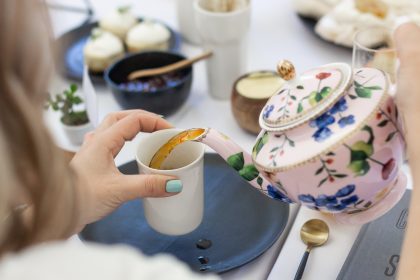 Tea being poured from porcelain tea pot at afternoon tea