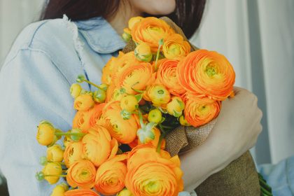Woman receiving bouquet of bring orange anniversary flowers