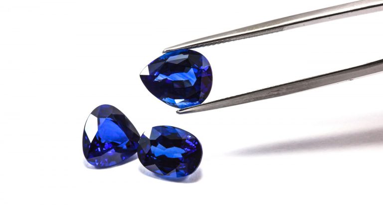 Group of the blue sapphires with tweezers