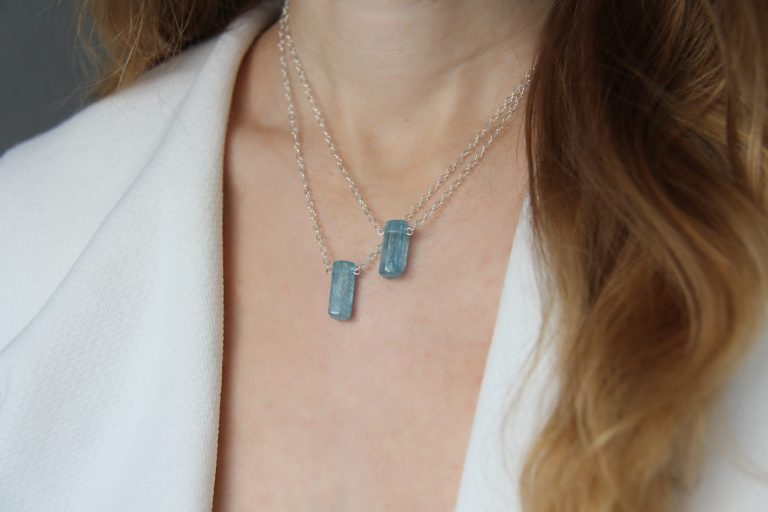 Crystal blue aquamarine pendant worn by woman