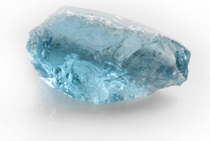 Raw blue topaz gem on white background