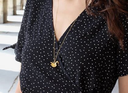 Woman wearing a gold origami necklace