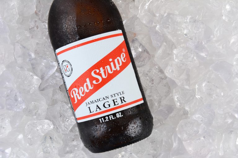 IRVINE, CA - JANUARY 11, 2015: Red Stripe Jamaican Style Lager on a bed of ice closeup. Brewed in Jamaica since 1938 by Desnoes & Geddes its international distribution is handled by Diageo.