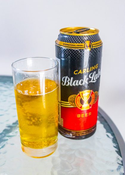 Carling Black Label beer can and glass on white background in Cape Town South Africa.