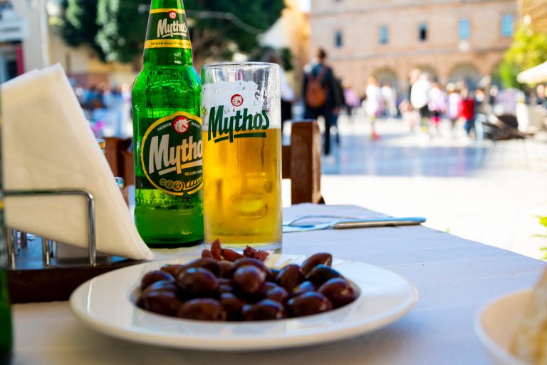 General view of a Greek Mythos Beer bottle and glass on a cafe t
