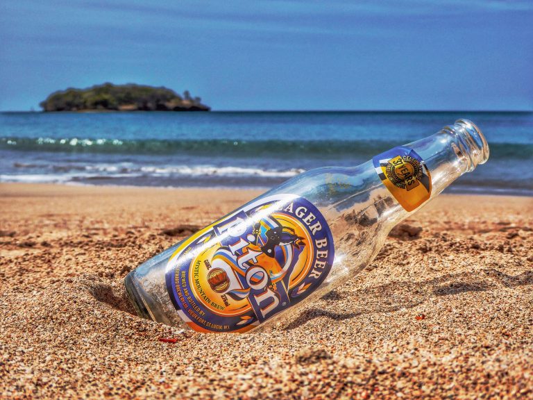 An empty bottle of Piton lager, on the beach in St. Lucia.