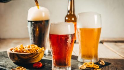 Different types of beer on rustic wood background