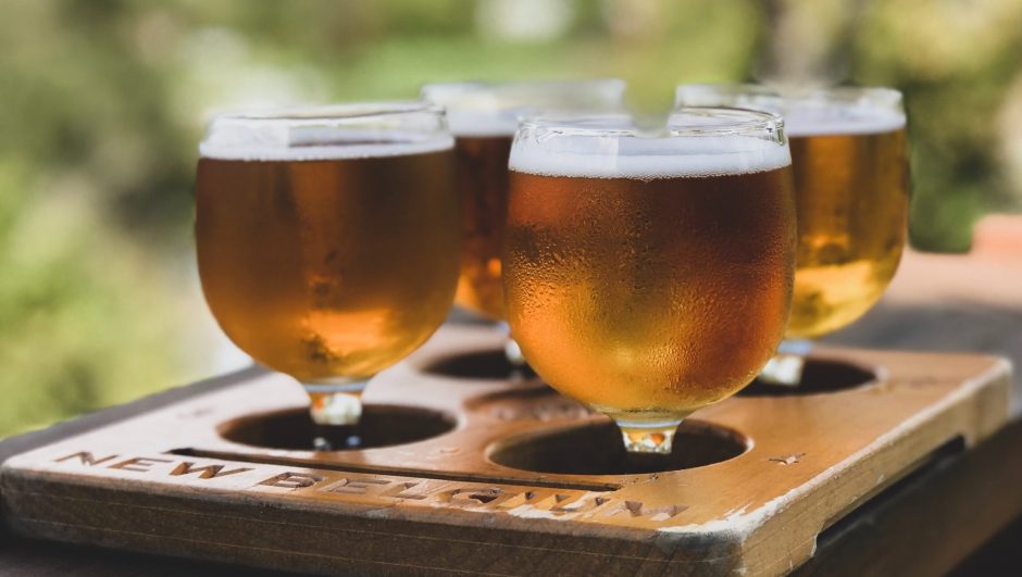 beer filled glasses in wooden tray