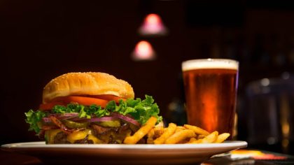 cold saison beer and grilled burger patty with fries