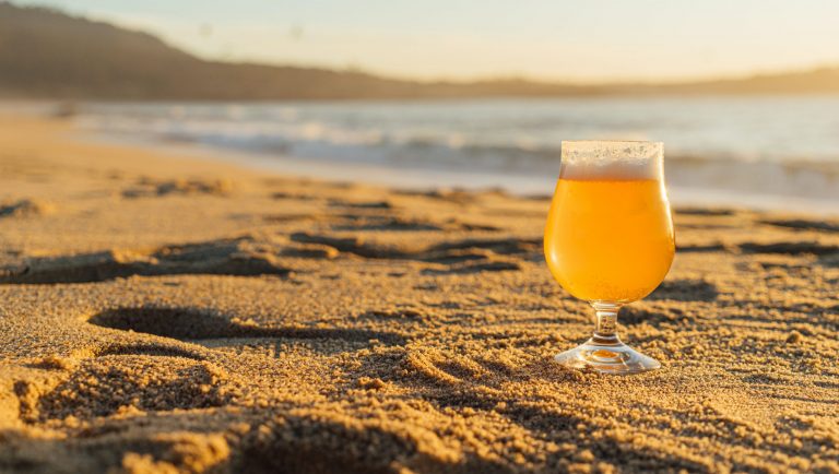 glass of beer in the sand